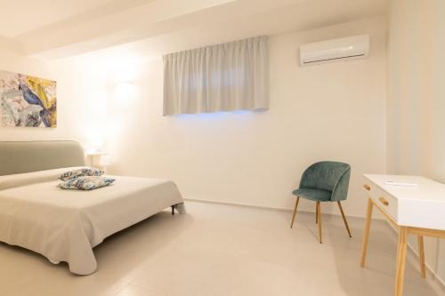 a bedroom with a bed and a desk and a chair at Villa Peter in Ostuni