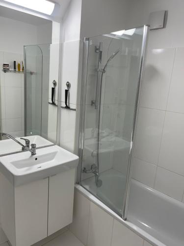 een witte badkamer met een douche en een wastafel bij Big room Zurich Center in Zürich