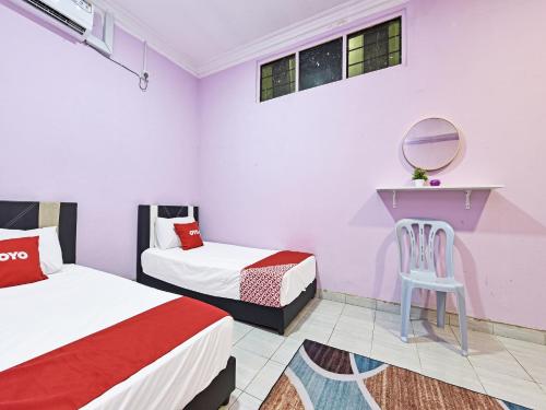 a bedroom with two beds and a mirror and a chair at OYO 90551 Zn Mix Homestay & Roomstay in Kampung Raja