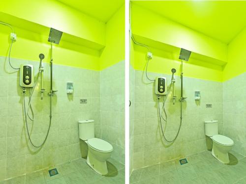a bathroom with two toilets and a shower at OYO 90551 Zn Mix Homestay & Roomstay in Kampung Raja