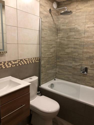 une salle de bain avec toilettes, baignoire et lavabo dans l'établissement L'Aubépine 2, à Montalbert