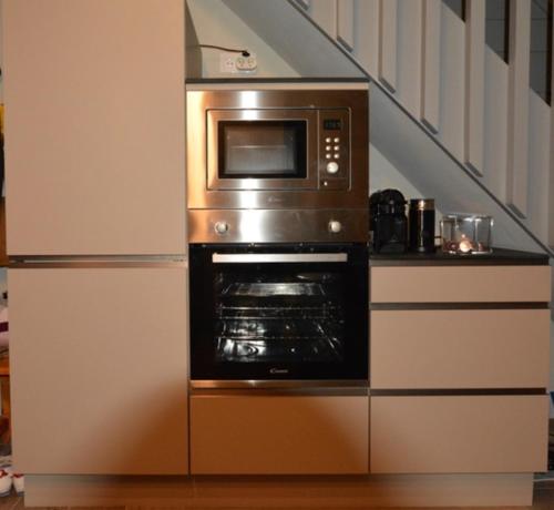 un horno microondas sentado en una cocina junto a una escalera en L'Aubépine 2 en Montalbert