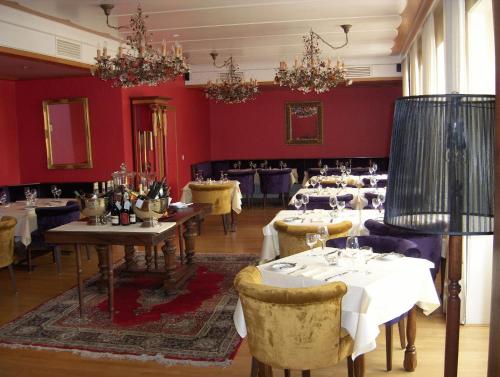 a dining room with tables and chairs and red walls at Hotel zum alten Brauhaus in Dudeldorf