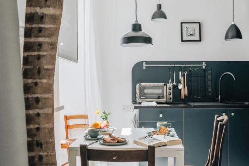 uma cozinha com uma mesa com comida e um micro-ondas em The Art Room Apartment em Cardigan
