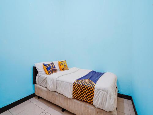 een bed met kleurrijke kussens in een kamer bij SPOT ON 91392 Pondok Basari in Bandung