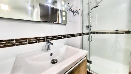 une salle de bain blanche avec un lavabo et une douche dans l'établissement Résidence Pistes - APPARTEMENT DUPLEX 4 PIECES 8/10 PERSONNES MAE-9304, au Corbier