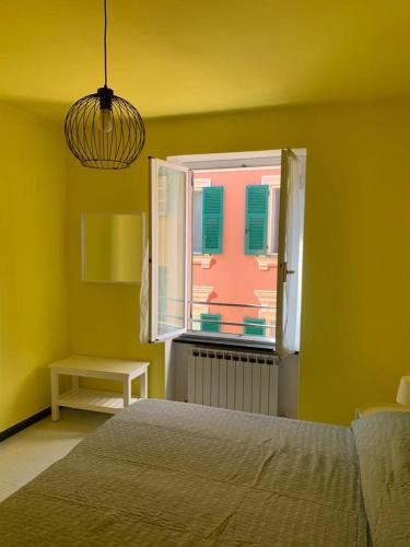 Schlafzimmer mit einem Bett und einem Fenster in der Unterkunft Appartamento Veneto by Vacanze in Chiavari in Chiavari