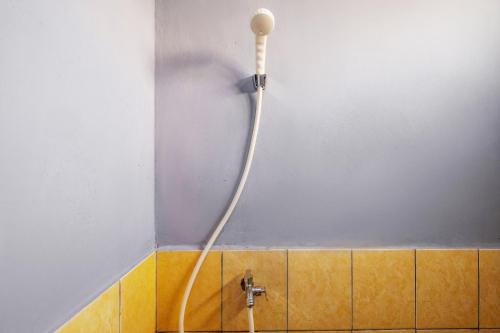 un bagno con tubo fissato a un muro di SPOT ON 91392 Pondok Basari a Bandung
