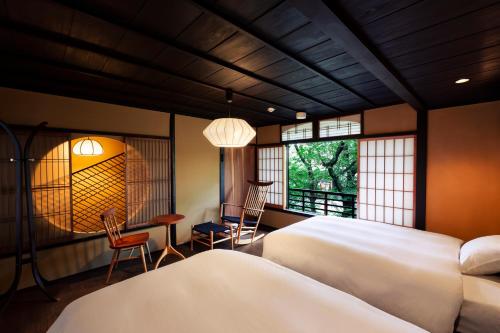 een slaapkamer met 2 bedden en een tafel en stoelen bij Rinn Shijo Takasegawa in Kyoto