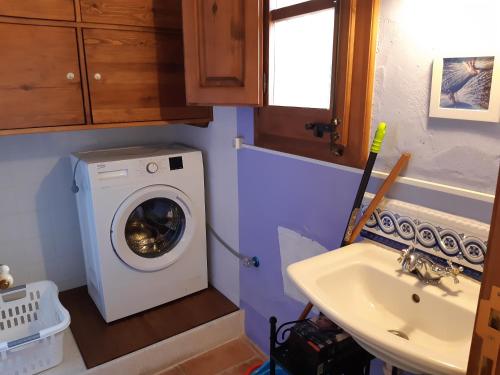a small bathroom with a washing machine and a sink at Mas del Salin in Cornudella