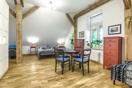 a dining room with a table and chairs and a bedroom at Stara Szkola Trzcin 20 in Trzcin