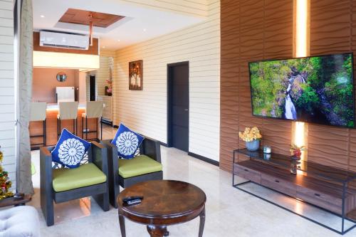 a living room with two chairs and a table at Bonheur at Karambunai in Kota Kinabalu