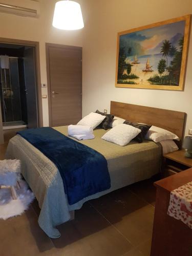 a bedroom with a large bed with a blue blanket at Mazzi House Garden in Dossobuono