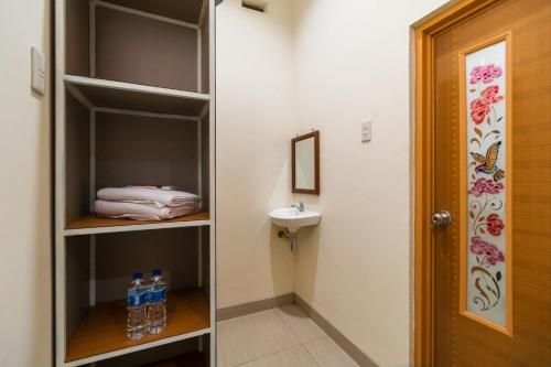 a walk in closet with a sink and water bottles at RedDoorz @ Aldos Villa Silangit in Siborongborong