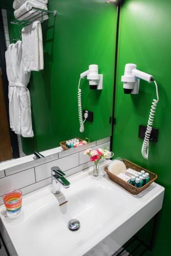 a green bathroom with a sink and a green wall at Molokan Inn Hotel in Baku
