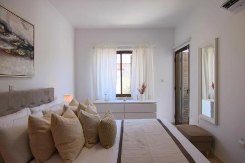 a white living room with a couch and a window at Phaedrus Living: City View Luxury Flat Androcleous in Paphos City