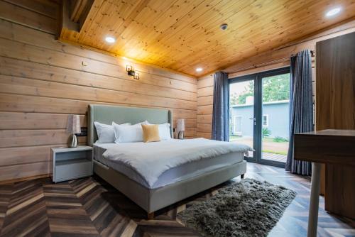 a bedroom with a bed and a wooden wall at SaffronStays Paradise Pines, Dehradun - cliff villa with valley & forest views in Dehradun