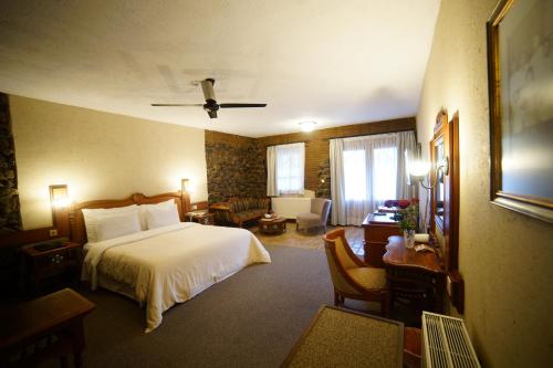 Cette chambre comprend un lit et un bureau. dans l'établissement The Mill Hotel, à Kakopetriá