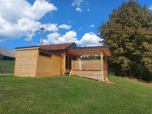 ein kleines Holzhaus auf einem Grasfeld in der Unterkunft Lahinja & Kolpa river apartments in Metlika