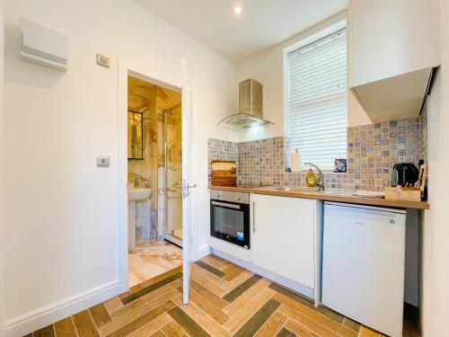 a kitchen with a sink and a counter top at Ashfield Boutique Stays in Altrincham