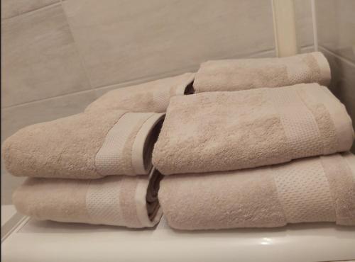stos ręczników siedzących na półce w łazience w obiekcie APARTAMENT - 2 pokoje w Łodzi - blisko Atlas Arena, Zoo, Centrum, Piotrkowska w Łodzi