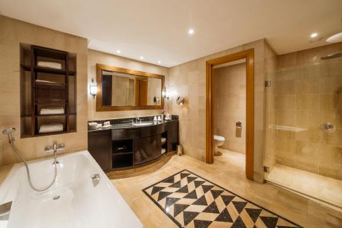 a bathroom with a tub and a sink and a shower at The Residence Tunis in Gammarth