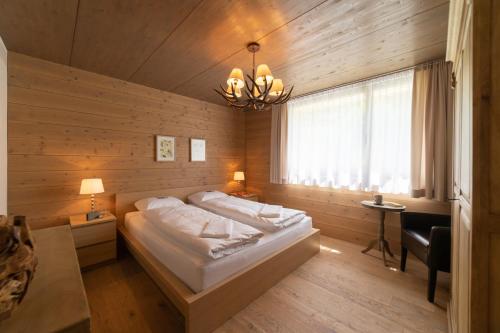 - une chambre avec un lit et un lustre dans l'établissement Primula, à Wildhaus