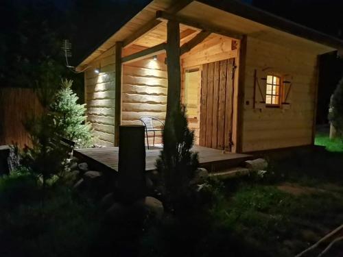 a log cabin with a deck at night at Siedlisko nad Jeziorem-Mazury in Mrągowo