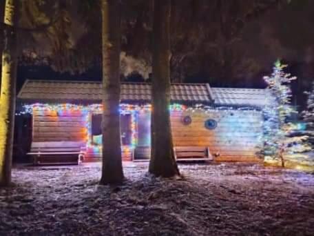 a log cabin with christmas lights in front of it at Siedlisko nad Jeziorem-Mazury in Mrągowo