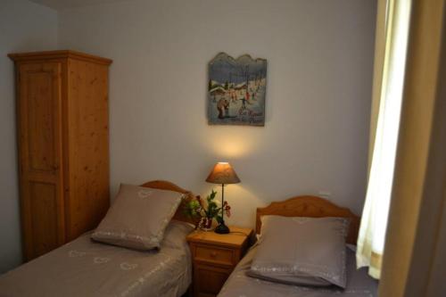 モンタルベールにあるLes Granges 22のベッドルーム1室(ツインベッド2台、ランプ付)
