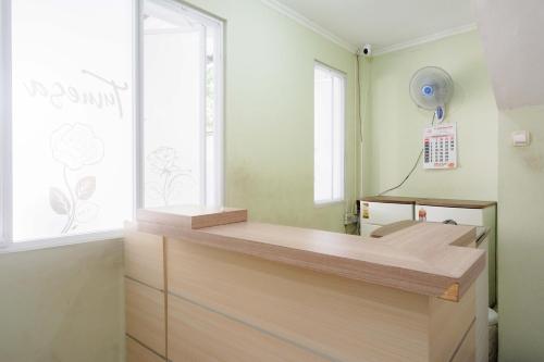 Cette chambre dispose d'un comptoir en bois et d'une fenêtre. dans l'établissement RedDoorz Syariah near Gerbang Tol Krapyak 2 Semarang, à Kalibanteng-kidul