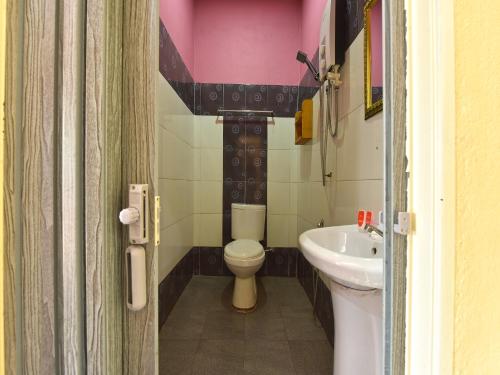 a bathroom with a toilet and a sink at OYO 90561 Awan Biru Motel in Pantai Cenang