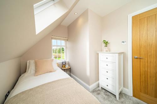 um quarto no sótão com uma cama e uma clarabóia em Robins Nest Cottage em Blairgowrie