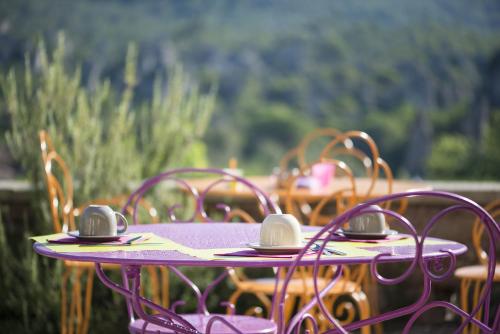 Mourèze的住宿－萊斯豪特斯莫雷茲酒店，紫色桌子和椅子,上面有耳机