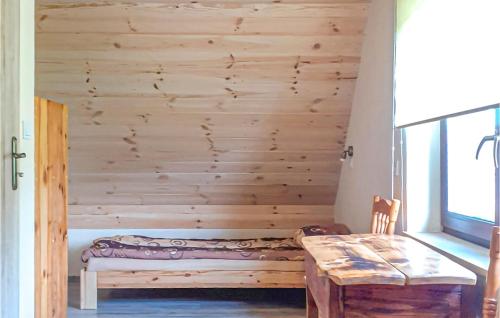 a room with a wooden wall with a bench and a table at Awesome Home In Dolistowo Stare With Kitchen in Dolistowo Stare