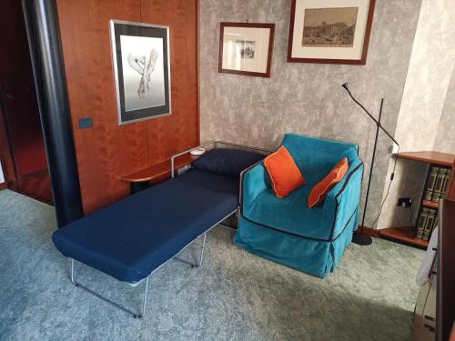 Habitación con sofá azul y silla en MILAN SOUTH GATE APARTMENT en Milán