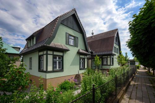 a green house with a black roof at Hotel Zelená Marina in Vrchlabí