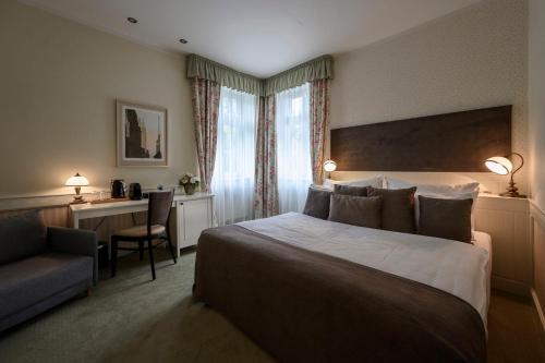 Pokój hotelowy z dużym łóżkiem i biurkiem w obiekcie Hotel Zelená Marina w Vrchlabi