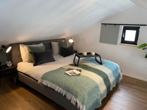 een slaapkamer met een bed met een tafel erop bij Appartement de Oude School in Heerlen