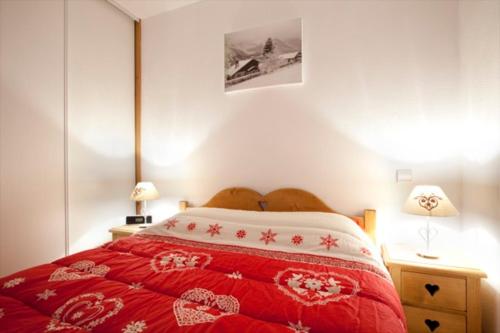 a bedroom with a red bed with a red and white blanket at Les Granges 14 for 10 people in Montalbert