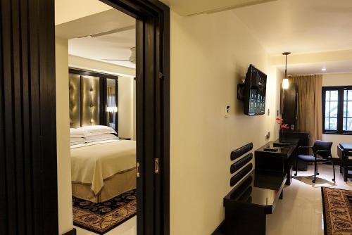 a bedroom with a bed and a desk and a mirror at Terra Nova, BW Premier Collection in Kingston