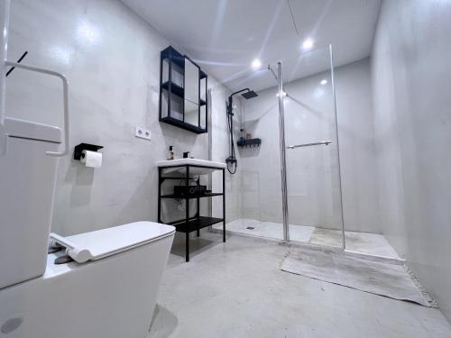 ein weißes Bad mit einer Dusche und einem WC in der Unterkunft HUG HOTEL2022 in El Carrer del Canonge