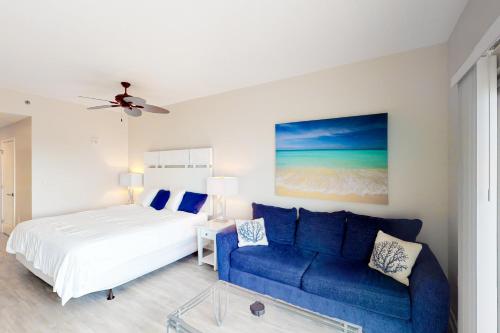 a bedroom with a bed and a blue couch at Sandestin Luau 6525 in Destin