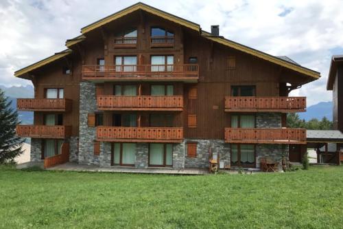 un grand bâtiment en bois avec balcon. dans l'établissement Le Chalet de Montalbert 25C, à Montalbert