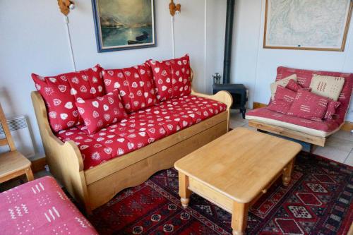 sala de estar con sofá y almohadas rojas en Chalet de Montalbert 32C 5-7 pers en Aime La Plagne