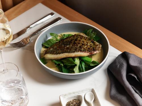 a bowl of food with a fish on a table at The Porter House Hotel Sydney - MGallery in Sydney