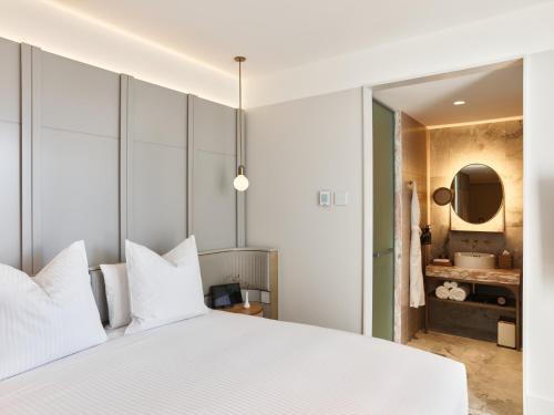 a bedroom with a white bed and a bathroom at The Porter House Hotel Sydney - MGallery in Sydney