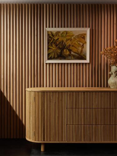 a painting on a wooden wall with a wooden shelf at The Porter House Hotel Sydney - MGallery in Sydney