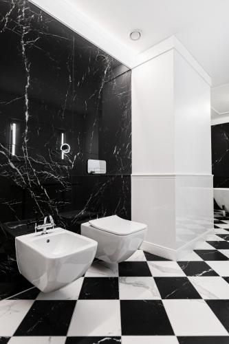 a black and white bathroom with a sink and a toilet at Grotthuss Boutique Hotel Vilnius in Vilnius