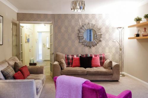 a living room with two couches and a mirror at Stylish family home in desirable Penylan + Parking in Cardiff